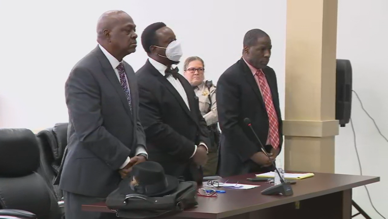Robert Lewis Henderson Jr. stands flanked by his attorneys as a Butts County judge reads his sentence on Dec. 8, 2021.