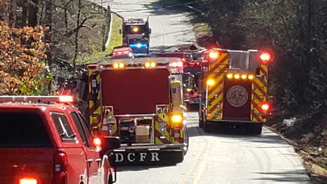 Fire crews rescue woman trapped in car pinned under dump truck
