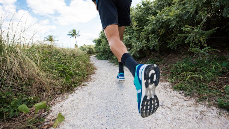 Young man exercising, running outdoors, rear view, low section, South Point Park, Miami Beach, Florida, USA