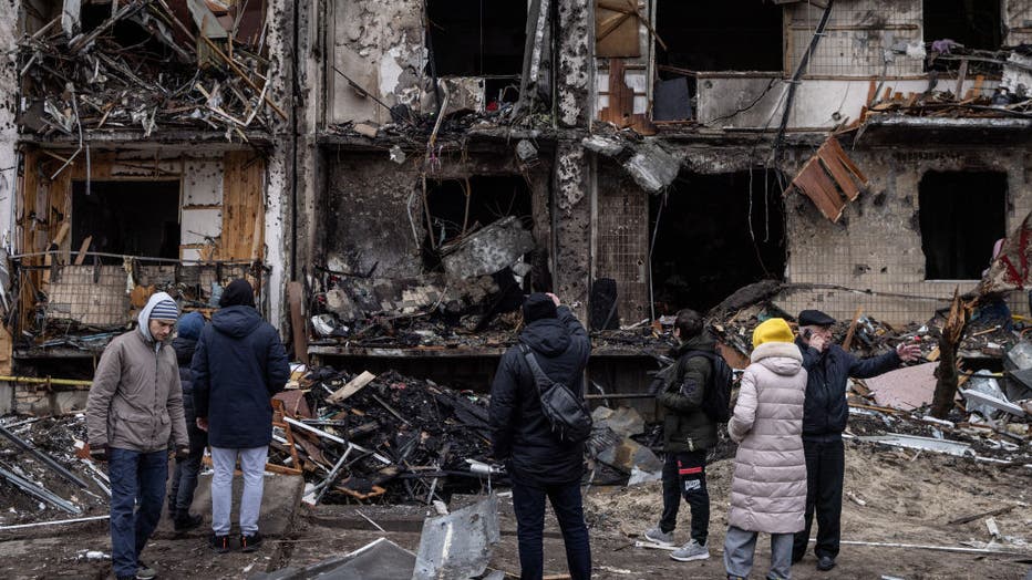 KYIV, UKRAINE - FEBRUARY 25: People look at the exterior of a damaged residential block hit by an early morning missile strike on Fe. 25, 2022, in Kyiv, Ukraine. (Photo by Chris McGrath/Getty Images)