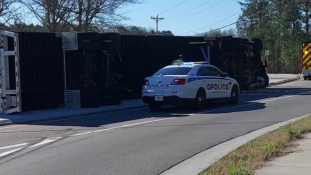 Tractor-trailer overturns, resting on median near Gwinnett County intersection
