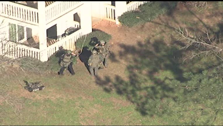 A SWAT team surrounds a DeKalb County apartment complex on Monday, March 14, 2022.