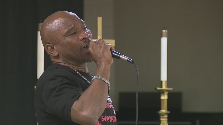 Coach Kenneth Miller sings during a prayer service and rally on March 17, 2022.