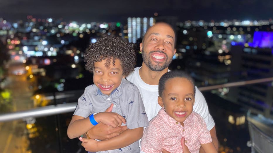 Dad hugs his two sons.