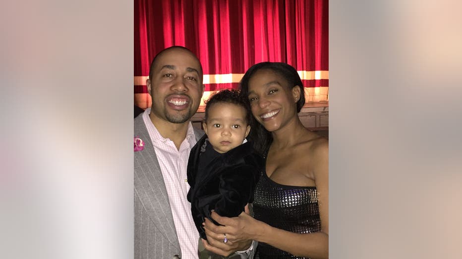 Couple hold toddler between them.