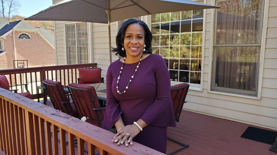 Reporter stands on her back porch, smiling for the camera.