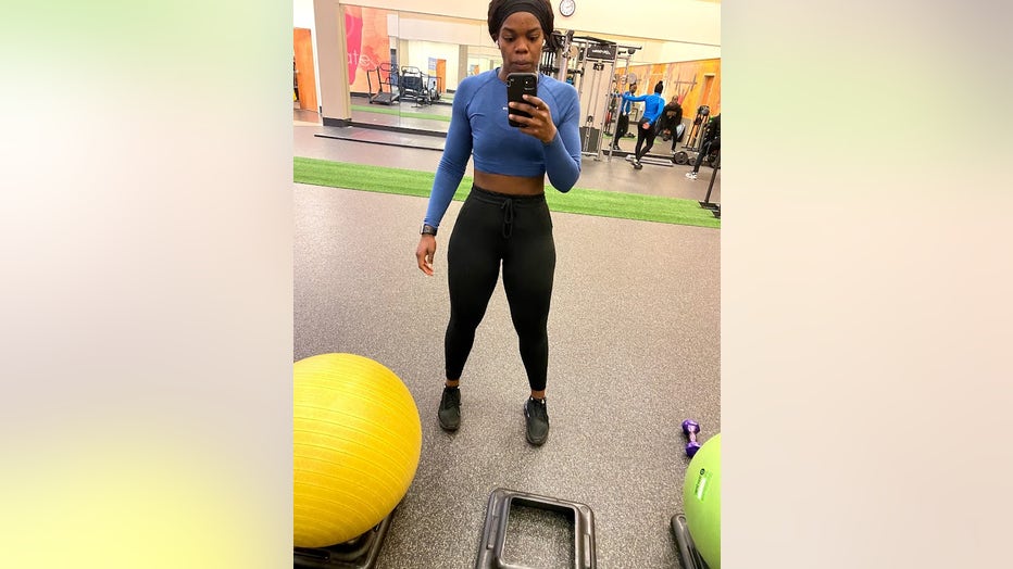 A woman who lost 150 pounds takes a selfie in front of a mirror at the gym.