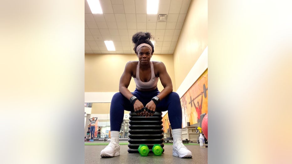 Woman sitting in gym and smiling at the camera