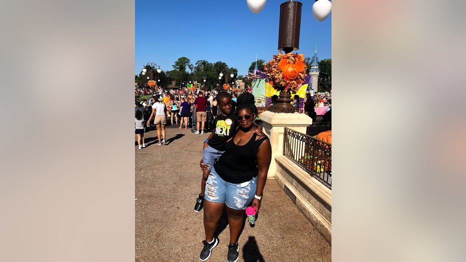 A woman holds her 5-year-old son at Disney World