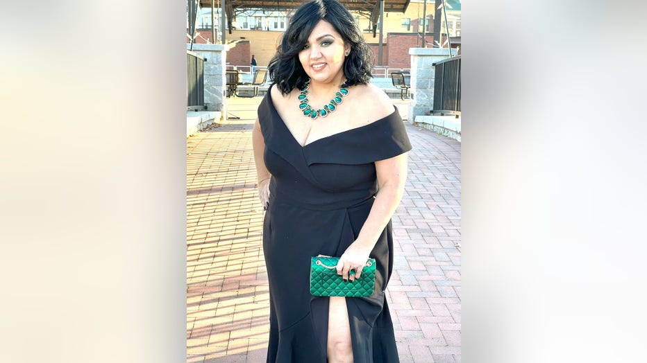 Woman poses in dark formal dress 