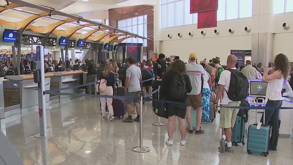 Passengers wait in line at the Delta Air Lines check-in at Atlanta's airport on Memorial Day 2022.
