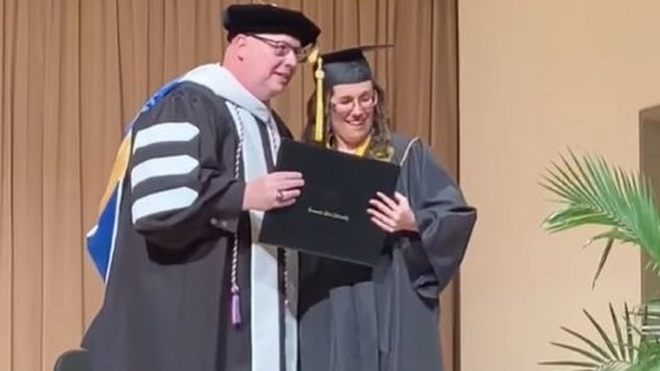 Emily Bowman poses at a graduation ceremony for KSU's Academy for Inclusive Learning and Social Growth students.