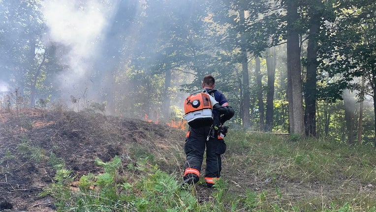 A firefighter works to create a backstop on a wildfire in Gainesville on June 19, 2022.