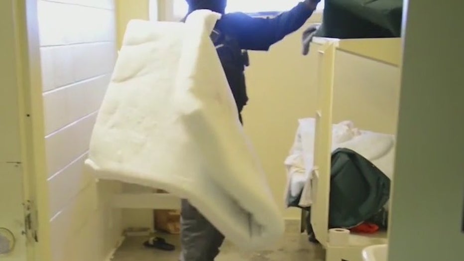 DeKalb County deputies, seen in an image from video provided by the sheriff’s office, search a jail cell for contraband.