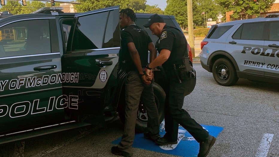 McDonough police escort 18-year-old Antwaun Thomas from a Dollar General store he is accused of robbing on the morning of June 14, 2022.