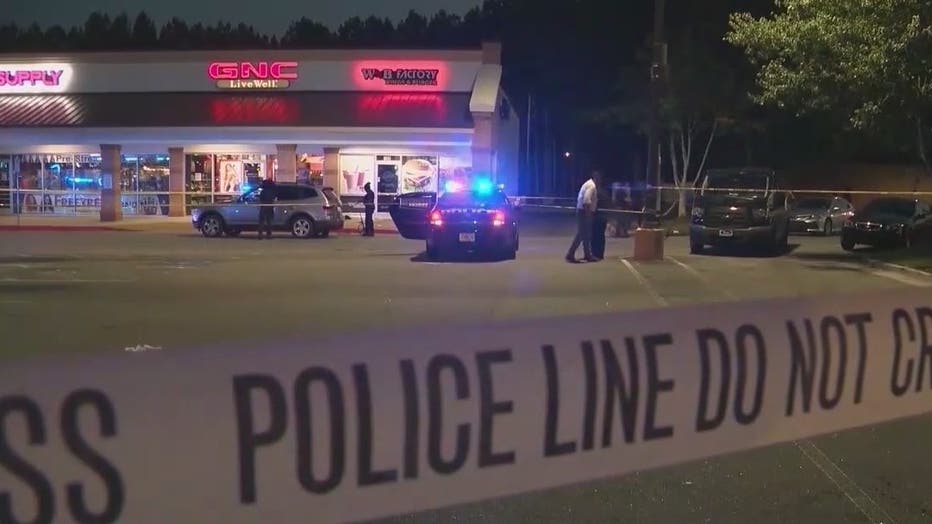 Police surround the parking lot of a DeKalb County grocery store where a teen was killed on June 12, 2022.
