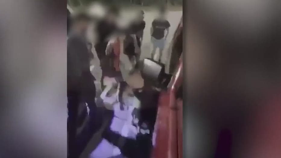 In this image from a video posted several times on social media, a Central High School graduate can be seen being kicked in the head on the ground of a parking lot of a Carrollton store as several teen watch.