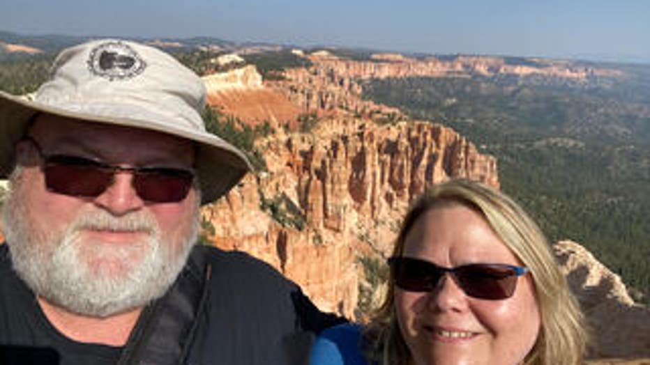 Woman in man stand against canyon backdrop while touring Utah.