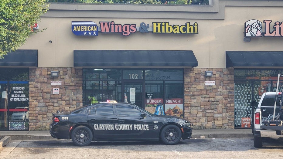 A Clayton County police cruiser sits in front of a Riverdale-area restaurant that investigators say was the focus of a homicide investigation on July 20, 2022.