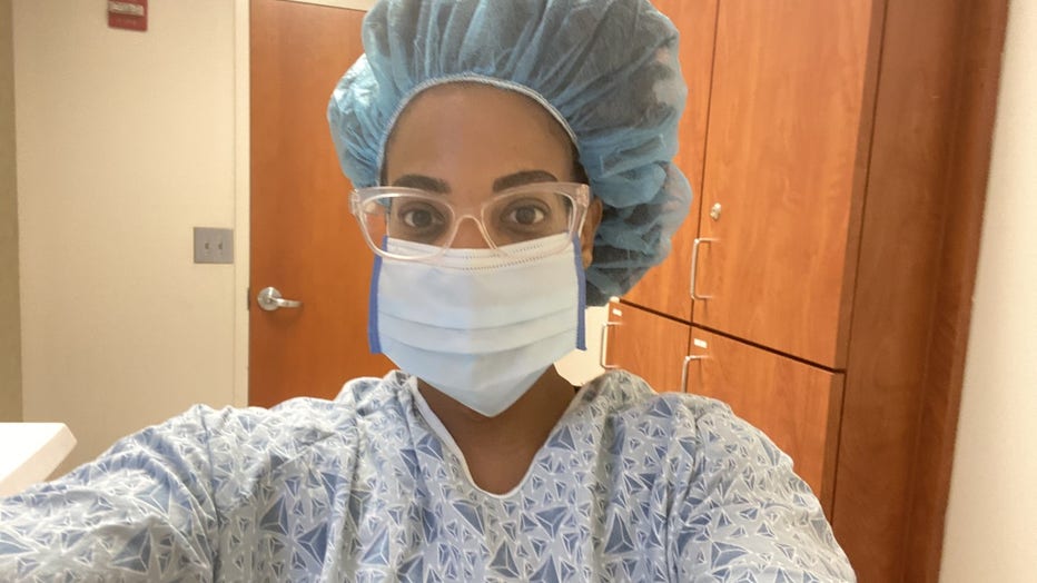 Woman in mask and hospital gown takes a selfie during her fertility treatment.