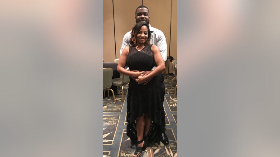 Husband and wife hug while posing for a photo.
