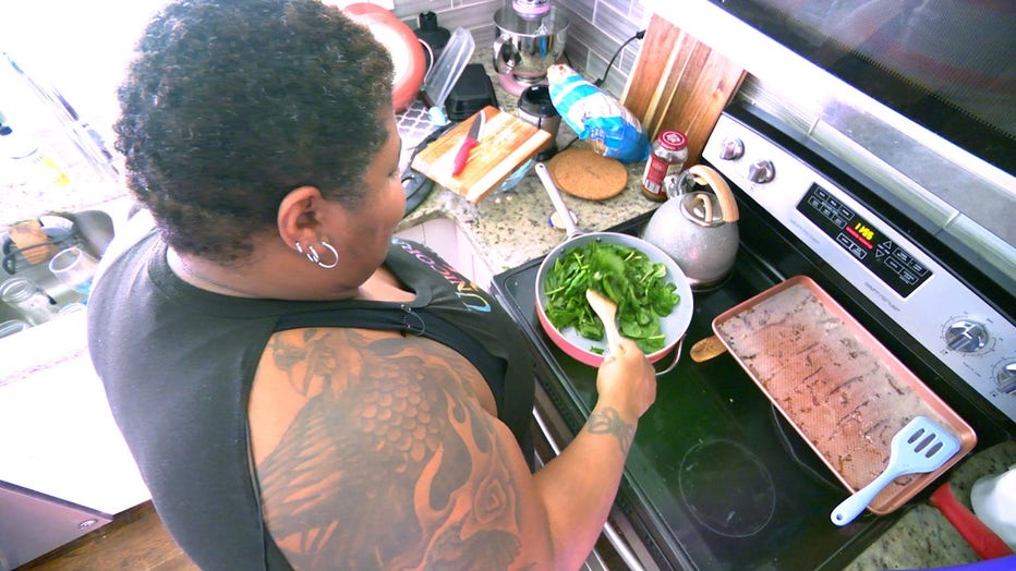 Woman cooks spinach on her stovetop