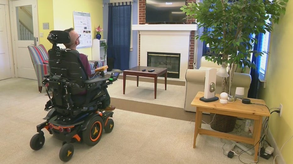 Matt McCoy testing out a system of magnetic sensors on his face and behind his ear allowing him steer his power wheelchair by tilting his head.