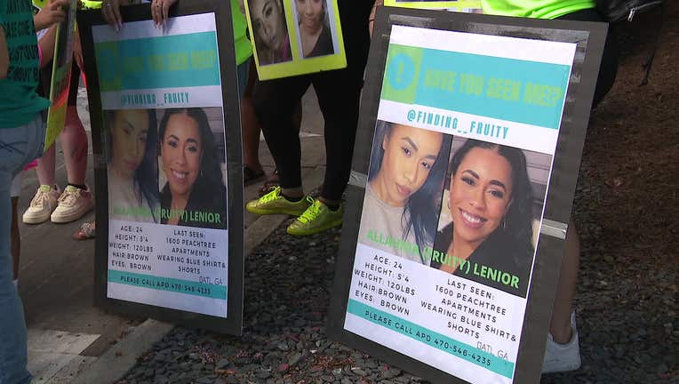 Friends and family of Allahnia Lenoir hold signs during a prayer vigil on Aug. 7, 2022 in Midtown.