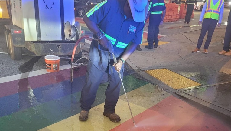 An Atlanta DOT worker pressure sprays a section of Midtown’s iconic rainbow crosswalk after a reported swastika was found spray-painted on it on August 17, 2022.