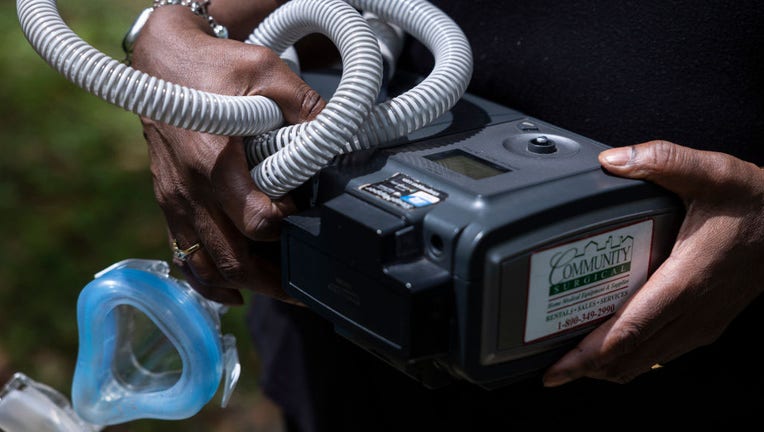 Jenny Shields poses for a photo with her CPAP machine, which wa