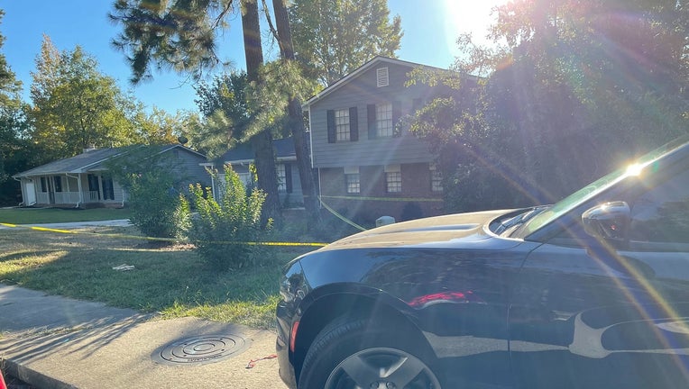 Investigators surround a home in northwest Atlanta after a man was found shot to death in the front yard on Oct. 6, 2022.