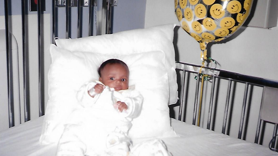 A small baby lies in a hospital bed after her second intestinal surgery.