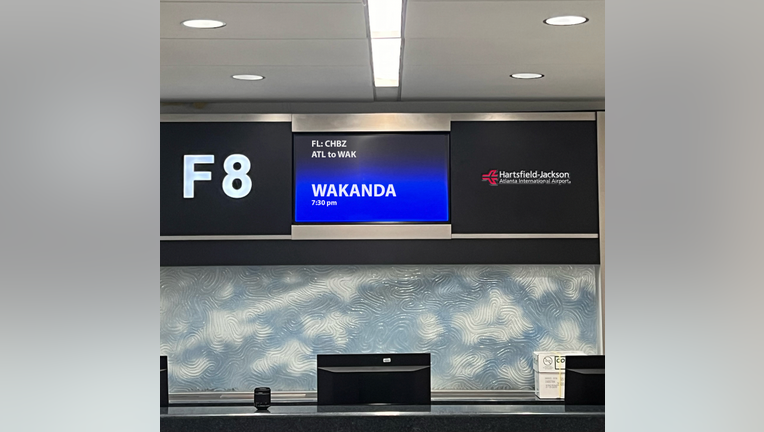 A sign indicating a flight to Wakanda, a fictional location from the "Black Panther" film series, at Hartsfield-Jackson Atlanta International Airport.