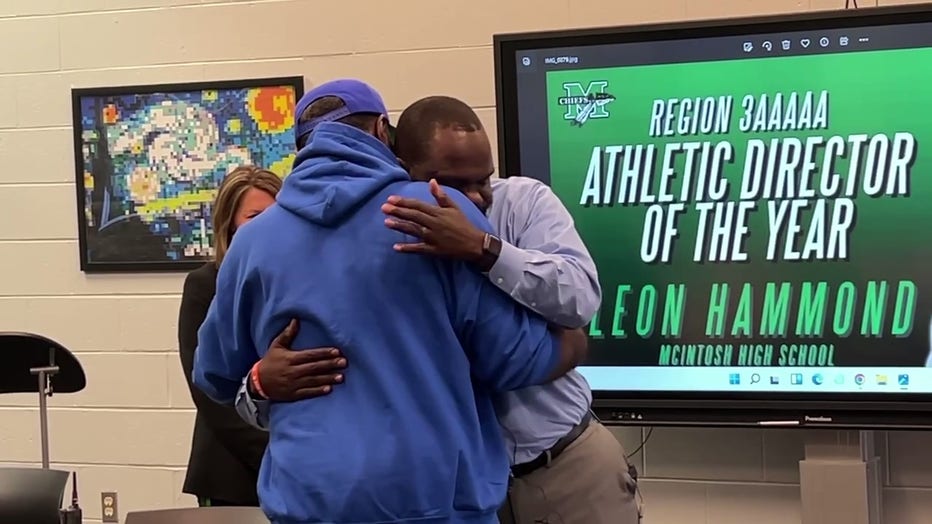 Former NFL player Willie Blackwell hugs McIntosh High School’s athletic director Leon Hammond moments after Hammond learned he would get a new kidney on Nov. 15, 2022.