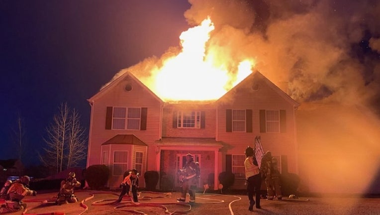 Firefighters battle a house a fire on Creek Cove Court near Loganville on Dec. 16, 2022.