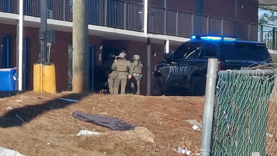 DeKalb County officers in tactical gear stand outside a motel on Dec. 28, 2022.