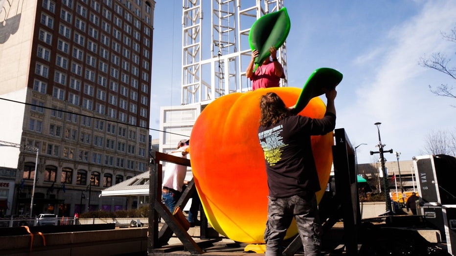 Workers construct the for the ahead of the big Peach Drop celebration at Underground Atlanta on Dec. 30, 2022.
