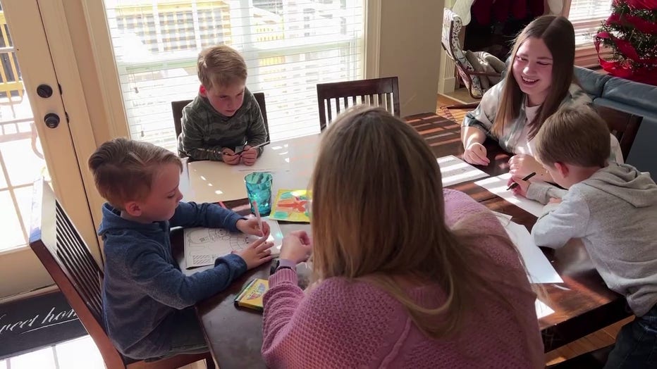 Natasha Zelinska sit with her teacher Bethany Lambert and her 5-year-old triplets, Whit, Tate and Mack.