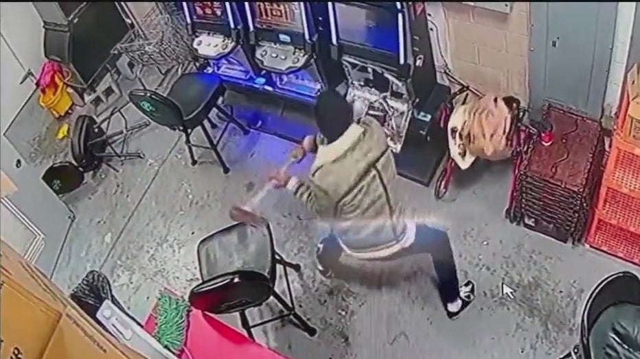 A still image from surveillance video at the Chevron Food Mart on Blair Bridge Road in Austell showing what police say is a man with an axe smashing a gaming machine on Nov. 22, 2022.