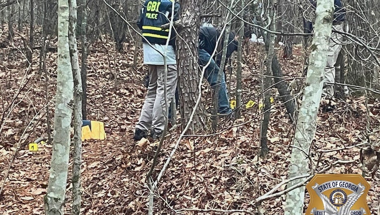 Investigators search an area of woods in Bartow County near the scene of an officer-involved shooting on Jan. 2, 2023.