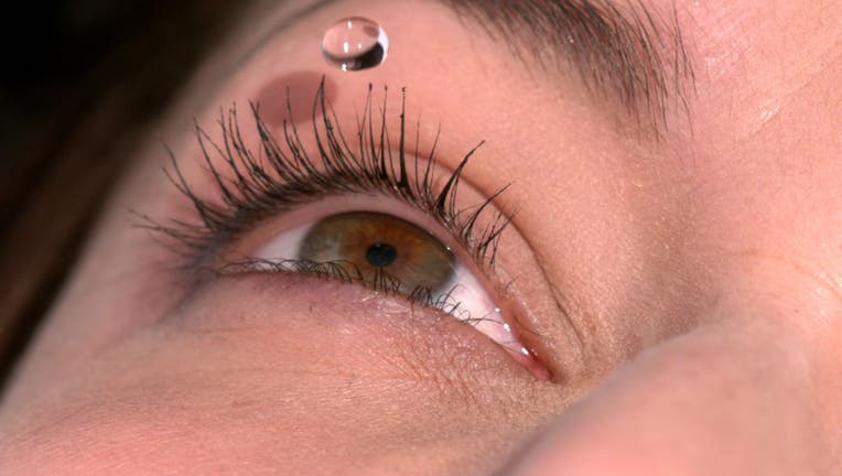 Eyewash drop over woman's eye