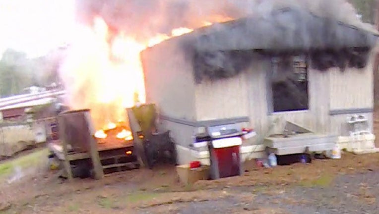 Cherokee County firefighters battle a deadly blaze at a mobile home along Victoria Road near Woodstock on Feb. 21, 2023.