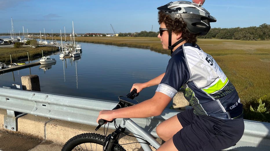 12-year-old boy rides his bike across a bridge on Amelia Island.