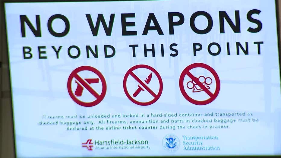 A sign at Atlanta’s airport warns about taking weapons past the security checkpoint.