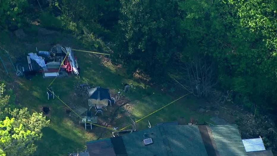 Crime scene tape surrounds the backyard of a Hall County home after a deputy-involved shooting on April 10, 2023.