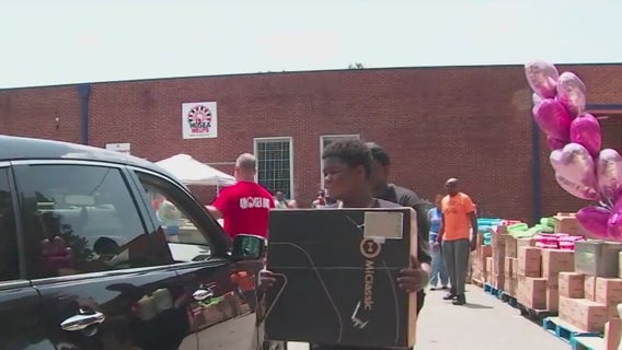 Hosea Helps distribute supplies to mothers during Mommy and Me Giveaway