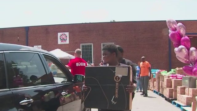 Hosea Helps distribute supplies to mothers during Mommy and Me Giveaway