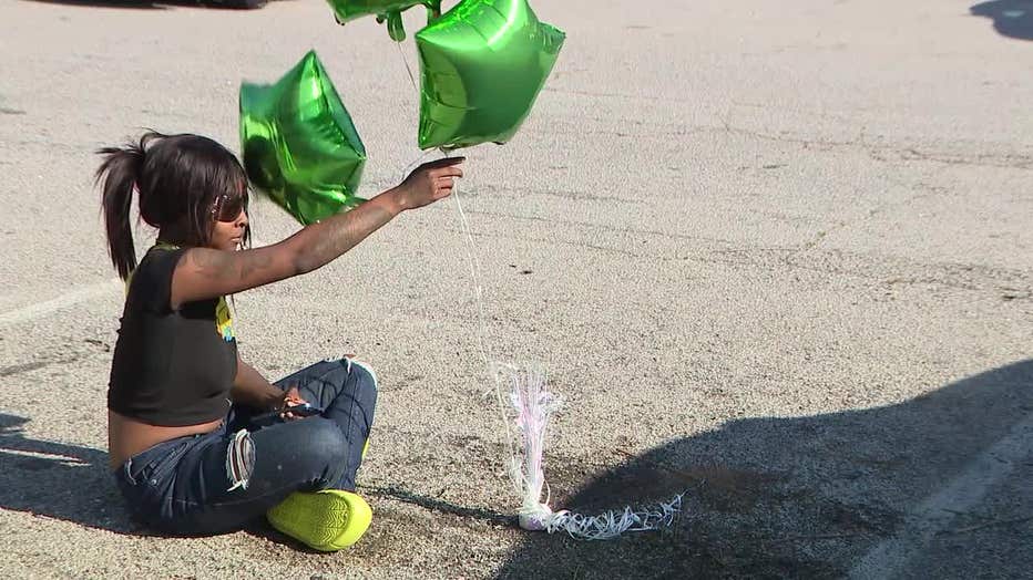 Family members of 25-year-old Jamiyah Parker place balloons at the spot she was gunned down at an apartment along Waldrop Trail in DeKalb County on May 29, 2023.