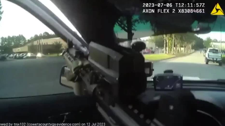 A deputy readies his rifle as he responds to an active shooter call at a Coweta County plant on July 6, 2023.