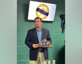 Rep. Austin Scott hands Crisp County Sheriff Hancock a flag flown over the U.S. Capitol to honor fallen Deputy Tyee Brown on Aug. 8, 2023.